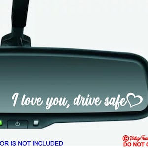 May include: White vinyl decal with the text "I love you, drive safe" and a heart symbol. The decal is shown on a rearview mirror.