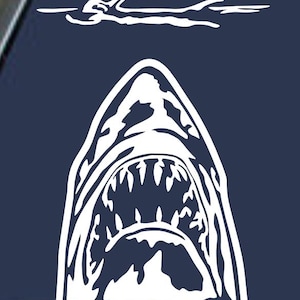 May include: White graphic of a shark's open mouth with sharp teeth, positioned below a swimmer silhouette. The design is on a dark blue background, evoking a sense of danger and the ocean. The text "Vintage Treasures Galore DO NOT COPY!" is in the bottom right corner.