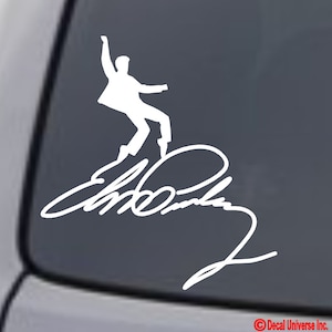 May include: White vinyl decal of a silhouette of Elvis Presley in a signature pose with his signature underneath. The decal is on a dark gray car window.