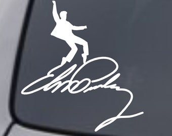 May include: White vinyl decal of a silhouette of Elvis Presley in a signature pose with his signature underneath. The decal is on a dark gray car window.