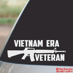 Puede incluir: Calcoman&iacute;a de vinilo blanco con la silueta de un rifle y las palabras "VIETNAM ERA VETERAN" en negrita y may&uacute;sculas. Dise&ntilde;ada para aplicarse en la ventana de un coche o superficie similar.