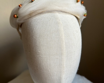Mini cappello vintage in tessuto avorio degli anni '50 con bordo in tulle attorcigliato e dettagli a rosetta in tessuto arancione