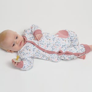 Neben Spielzeug liegend, rosa Einfassung entlang Knopfleiste sichtbar, strampler mit druckknöpfen, baby strampler pdf schnittmuster