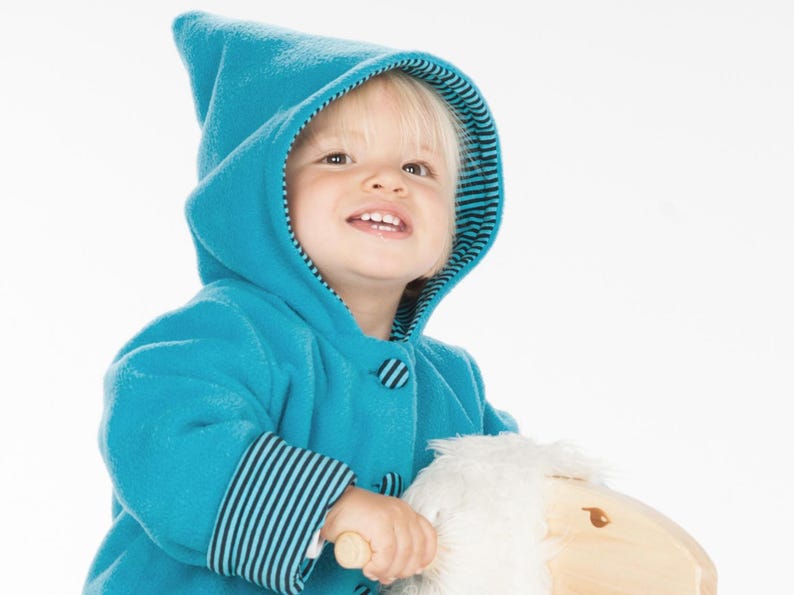 Fröhliches Kleinkind im Zipfelkapuzen Detail, gestreifte Kapuzeninnennaht, zipfelkapuze babyjacke nähen