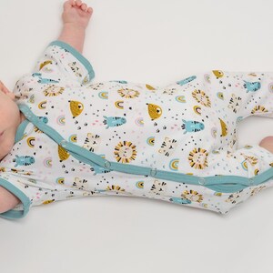 Baby liegt entspannt im kurzen Overall, diagonale Knopfleiste bis Bein, ideales baby schlafanzug schnittmuster Beispiel
