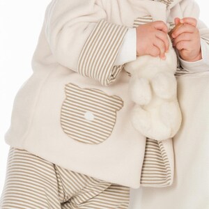 Detailaufnahme Tasche mit Streifen, Holzknopf am Saum, weiche Nahtverarbeitung, babyjacke mit kapuze nähen Anleitung