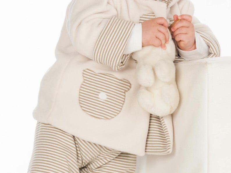 Detailaufnahme Tasche mit Streifen, Holzknopf am Saum, weiche Nahtverarbeitung, babyjacke mit kapuze nähen Anleitung