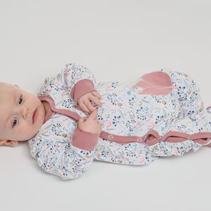 Kleine Aufnahme, Baby hält Spielzeug, Allover-Print und applizierte Tasche sichtbar, baby strampler pdf schnittmuster, anfänger schnitt