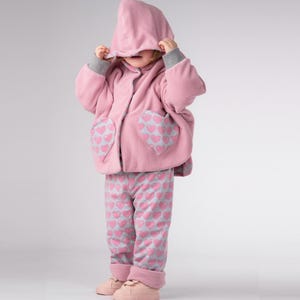 Mädchen zieht Kapuze hoch, sichtbarer Reißverschluss vorne, Wendeponcho Kinder, Kapuzponcho Schnittmuster