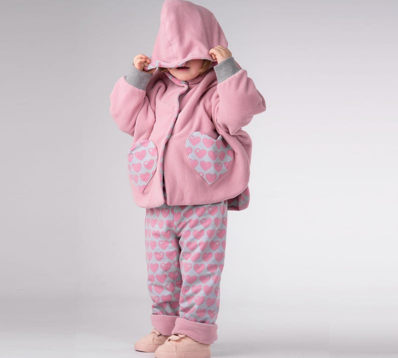Mädchen zieht Kapuze hoch, sichtbarer Reißverschluss vorne, Wendeponcho Kinder, Kapuzponcho Schnittmuster