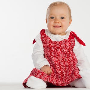 Glückliches Baby sitzt, rotes Blumenkleid über Body, einfaches babykleid nähen, anfängerfreundlich