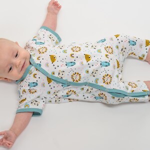 Fröhlich lächelndes Baby im Langarm-Strampler, lockere Passform, bunter Tierprint, jersey baby strampler schnittmuster