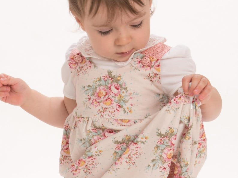 Nahaufnahme, Baby hält den eingekräuselten Rock, gefütterte Passe sichtbar, schnittmuster babykleid anfänger