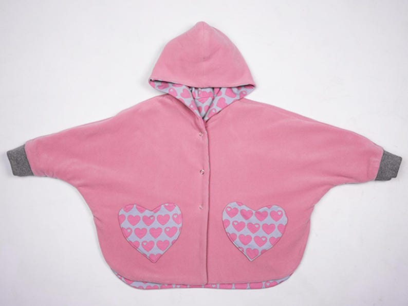 Flach gelegt Vorderseite mit Herztaschen und Zipper, Wendeponcho Kinder, Mara Poncho Schnittmuster