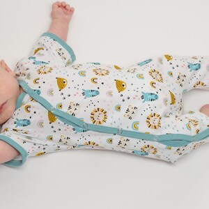 Schräg liegender Baby-Strampler, Detail der Beinabschlüsse und Prints, baby einteiler schnittmuster für Sommer und Langarm Variante