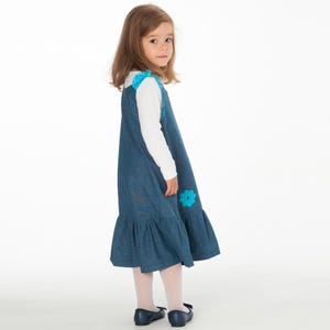 Tunika Kleid Schnittmuster Kinder, seitliche Ansicht blaues Pinafore mit Tasche, fallender Saum
