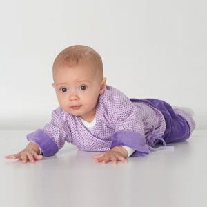 Krabbelndes Baby in locker sitzender Wickeljacke, überschnittene Schultern sichtbar, babyjacke nähen anleitung