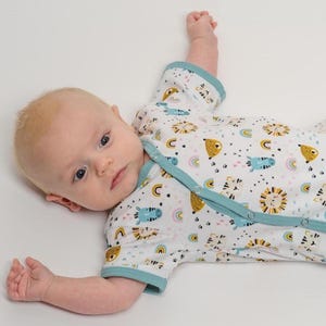 Großes Detail des Ausschnitts und der Druckknopfleiste am lockeren Strampler, strampler mit druckknöpfen, baby strampler schnittmuster pdf