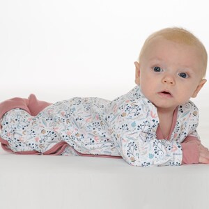 Auf dem Bauch, Kopf erhoben zur Kamera, praktische Knopfleiste gut sichtbar, baby schlafanzug schnittmuster, baby strampler pdf schnittmuster