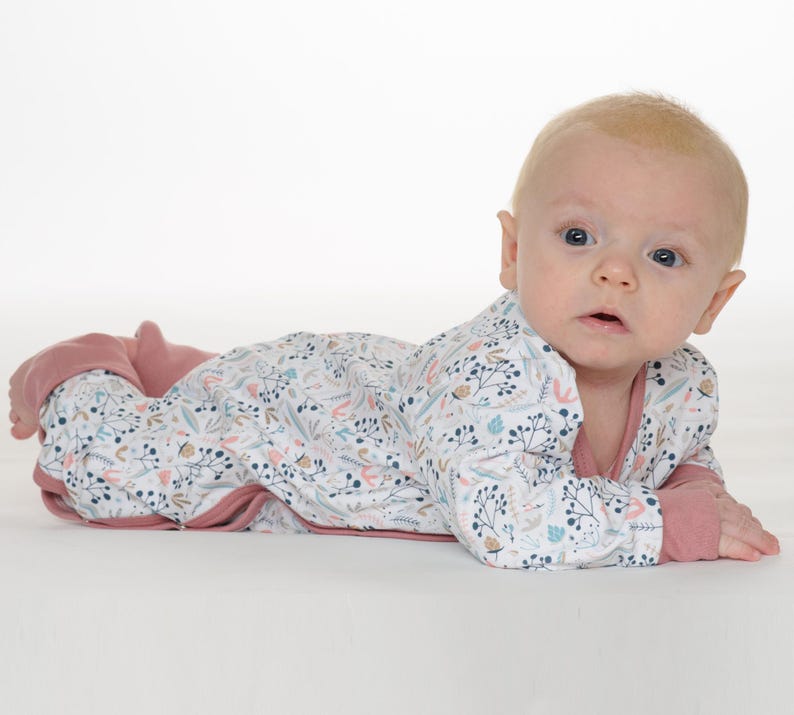 Auf dem Bauch, Kopf erhoben zur Kamera, praktische Knopfleiste gut sichtbar, baby schlafanzug schnittmuster, baby strampler pdf schnittmuster