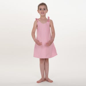 Rüschenkleid Schnittmuster, Mädchen frontal im karierten Trägerkleid, dezente Rüschen am Saum