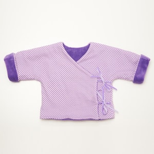 Flachgelegte fliederfarbene V-Ausschnitt-Jacke aus Jersey mit Kontrastbündchen, baby cardigan schnittmuster pdf