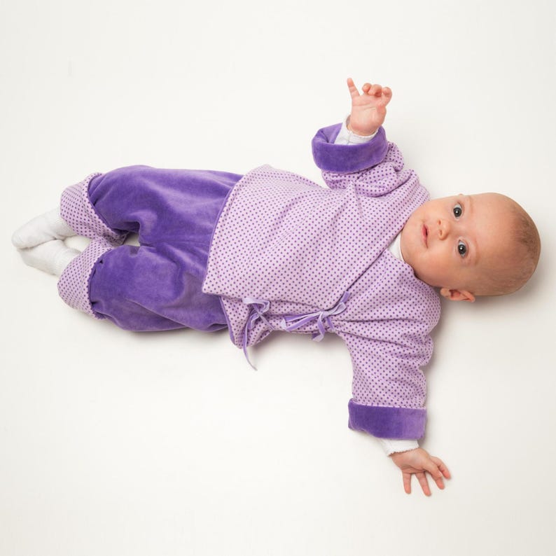 Ruhendes Baby in weicher Fliederjacke, Nahtdetails und Bündchen betont, baby kleidung schnittmuster pdf