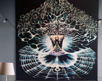 May include: A black tapestry with a psychedelic design of a tree with a face in the center. The tapestry is hanging on a gray wall above a beige armchair with a brown throw blanket.