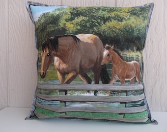 May include: A brown and white horse and a brown foal walk across a wooden fence in a green field. The horse and foal are walking towards the right side of the image.