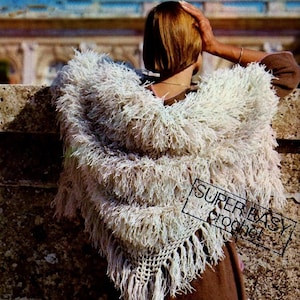 May include: A white crocheted shawl with a fringe border. The shawl is draped over a person's shoulders. The text "SUPER EASY crochet" is visible in the lower right corner of the image.