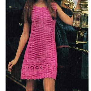 Può includere: Un mini abito rosa in crochet con orlo a balze e dettagli floreali. L'abito è senza maniche e ha una scollatura quadrata.