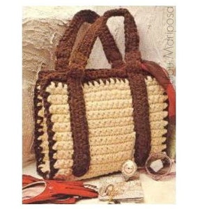 Puede incluir: Un bolso de mano de crochet con correas marrones y un cuerpo beige. El bolso tiene un borde de crochet alrededor de los bordes.