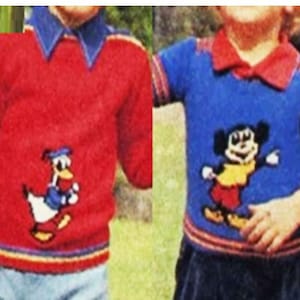 Può includere: Due bambini indossano maglioni rossi e blu con personaggi dei cartoni animati ricamati. Il maglione rosso presenta un'anatra con un cappello da marinaio e il maglione blu presenta Topolino.