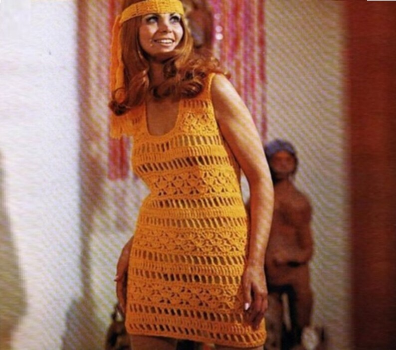 May include: A woman wearing a sleeveless, yellow crochet dress with a crocheted headband. The dress has a scoop neckline and a loose fit.