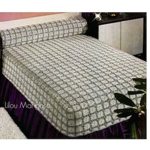 Pode incluir: Uma colcha de cama branca de crochê com um padrão quadrado. A colcha está sobre uma cama com uma saia de cama roxa e um travesseiro de apoio de crochê branco.