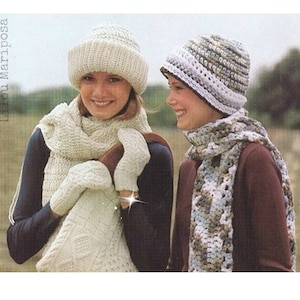 May include: Two women wearing crocheted hats and scarves. One woman is wearing a white hat and scarf, the other is wearing a multi-colored hat and scarf.