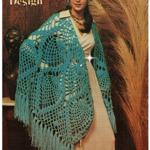 May include: A teal crochet shawl with a pineapple design and fringe. The shawl is draped over a woman's shoulders. The text "Crochet Shawl - Pineapple Design" is visible at the top of the image.
