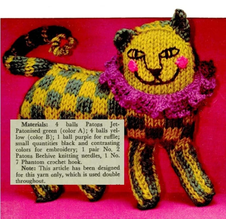 May include: A knitted toy cat with a yellow and green striped body, a purple ruffle collar, and pink cheeks. The cat is standing on a pink surface. The text "Materials: 4 balls Patons Jet-Patonised green (color A); 4 balls yellow (color B); 1 ball purple for ruffle; small quantities black and contrasting colours for embroidery; 1 pair No. 2 Patons Beehive knitting needles, 1 No. 7 Phantom crochet hook. Note: This article has been designed for this yarn only, which is used double throughout." is printed below the cat.