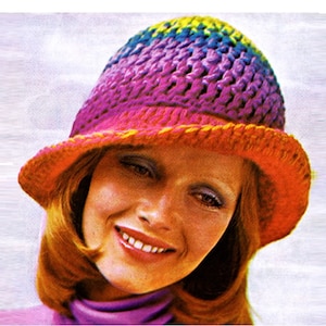 May include: A crocheted hat with a wide brim. The hat is made in a rainbow gradient of colors, starting with yellow at the top and transitioning to orange, pink, purple, and blue. The brim is a solid orange color.