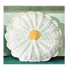 May include: A white crocheted daisy flower with a yellow center. The flower is about 6 inches in diameter.