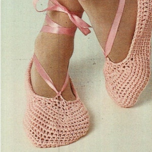 May include: A pair of pink crocheted ballet slippers with pink satin ribbon ties.
