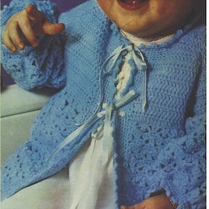 May include: A blue crocheted baby cardigan with white ribbon ties. The cardigan has a lace pattern and a scalloped edge.