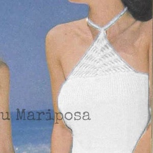 Peut inclure: Top en crochet blanc avec un motif géométrique. Le haut a une fermeture à nouer au cou.