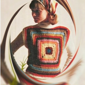 May include: A woman wearing a colorful crocheted vest with a white crocheted hat.