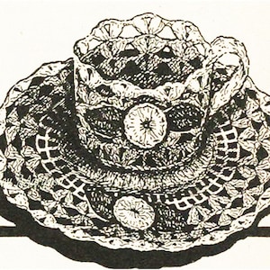 May include: A black and white illustration of a crocheted cup and saucer set. The cup and saucer are decorated with intricate patterns and have a delicate, vintage aesthetic.