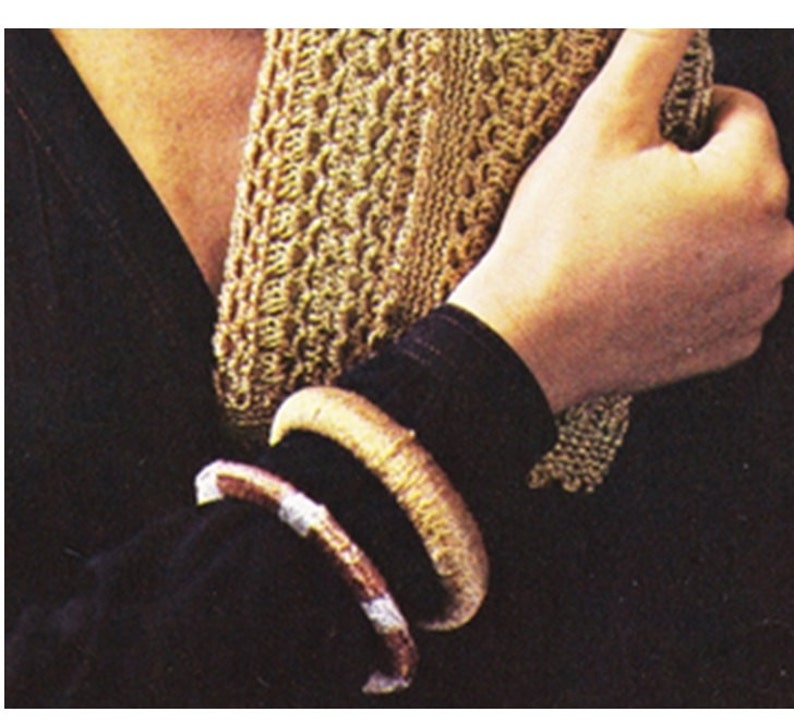 May include: Two brown and gold bracelets on a person's wrist. The bracelets are made of woven material and have a natural, rustic look.