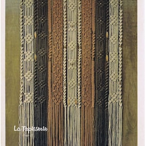 May include: A macrame wall hanging with vertical panels in shades of beige, brown, and black. The design includes knotted patterns, wooden beads, and fringe at the bottom. The text "La Tapisserie" is visible. A decorative textile.