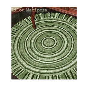 May include: A green crocheted round rug with a fringe border. The rug has a concentric circle pattern with alternating light and dark green yarn.