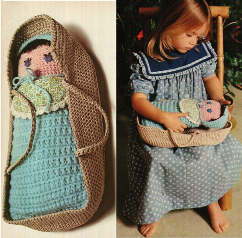 May include: A crocheted baby doll in a brown crocheted bassinet. The doll is wearing a blue and white dress and a floral print bonnet. The bassinet has a handle on each side.