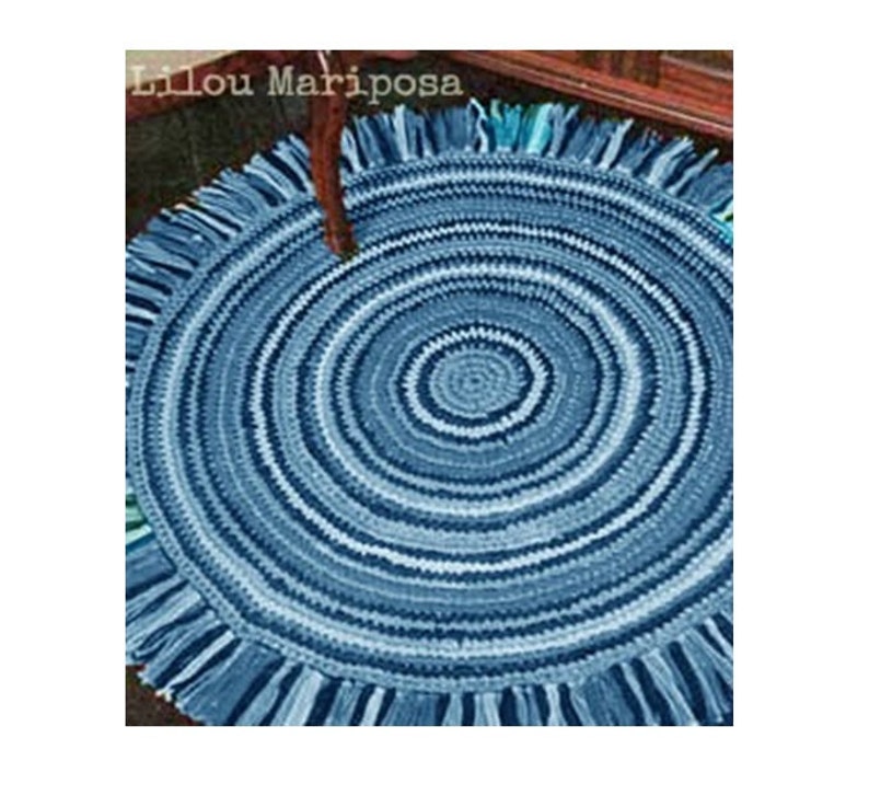 May include: A blue and white crocheted round rug with a fringe border. The rug has a concentric circle pattern.